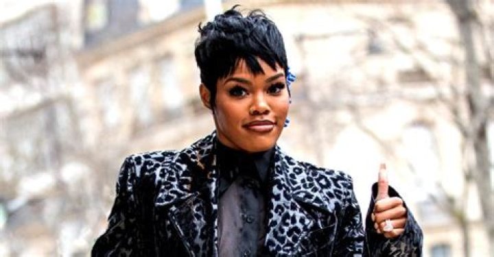 Teyana Taylor Shows off Her Long Legs as She Poses in Bodysuit & Belted Black Coat at Paris Fashion Week