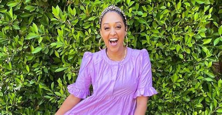 Tia Mowry Poses in Cute Purple Medium Length Dress and Animal Print Headband