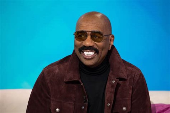 Steve Harvey Poses Outdoors in Dubai Wearing a Trendy Black & White Winter Outfit & Sunglasses