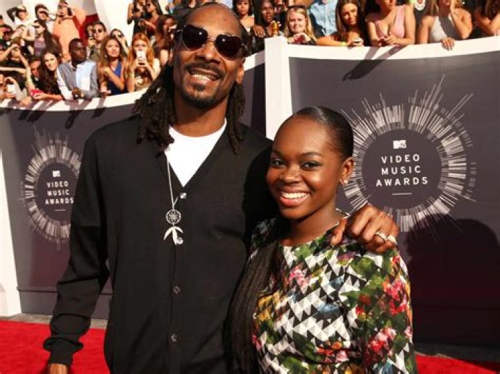 Snoop Dogg's Daughter Cori Flaunts Deep Cleavage in a White Swimsuit Posing with Shirtless Boyfriend
