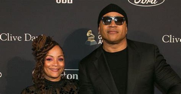 LL Cool J’s Wife of 26 Years Flaunts 3 Tattoos in Red Blouse & Floral Skirt Sitting on Wooden Log Rounds