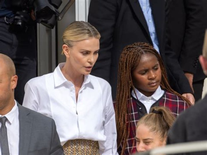 Charlize Theron’s Dimpled Daughter, 7, Flaunts $3,400 Purse Sitting Front Row at a Fashion Show, Sparking Talks